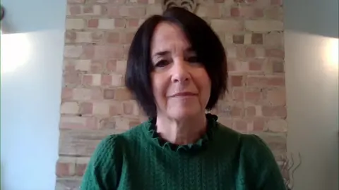 Andrea Brady, que tiene el pelo corto de color castaño oscuro y viste un jersey de punto de ochos verde, habla con BBC Breakfast a través de un enlace de Zoom desde su casa.