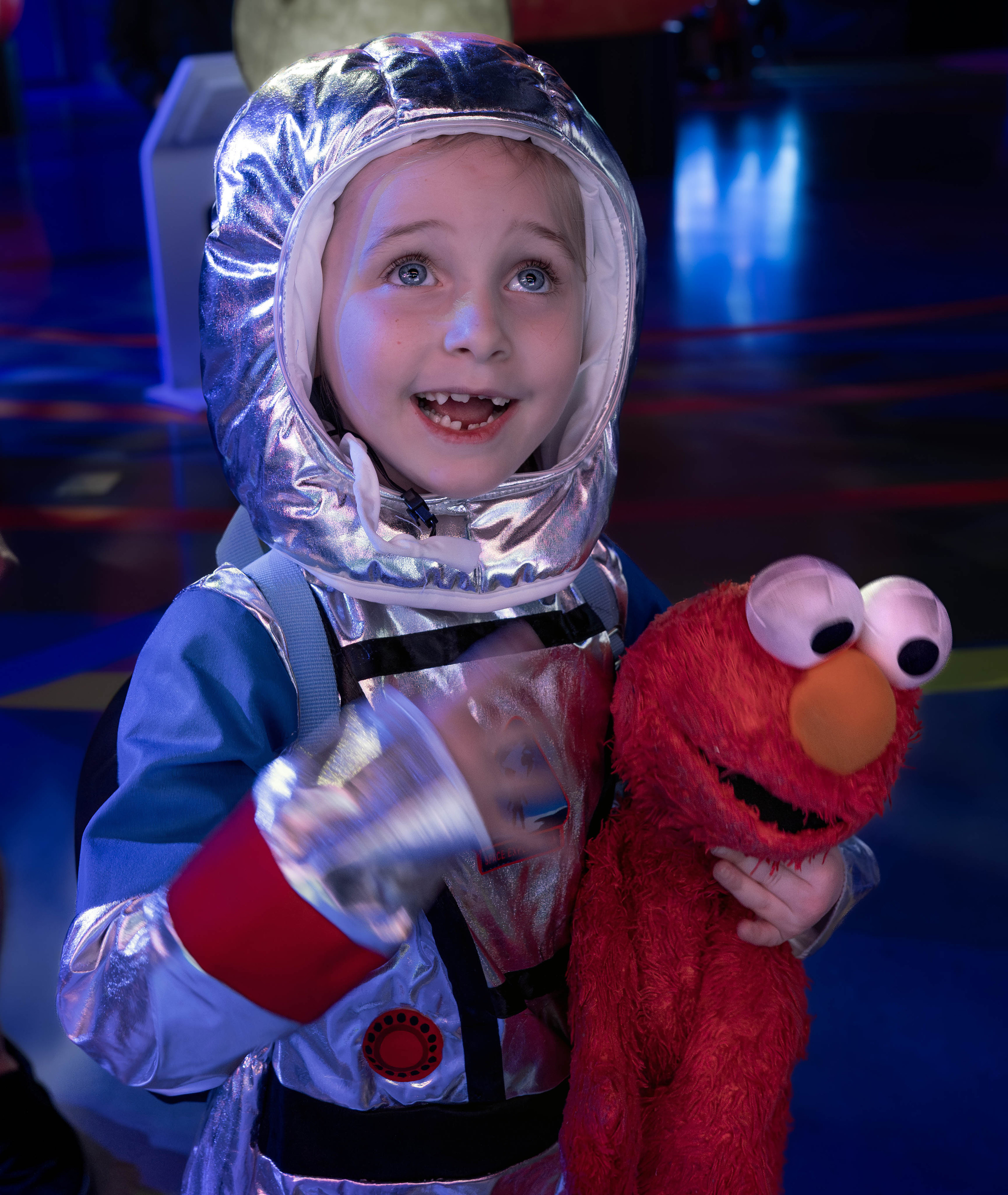 Vestido como un astronauta y sosteniendo su muñeco de peluche Elmo,…
