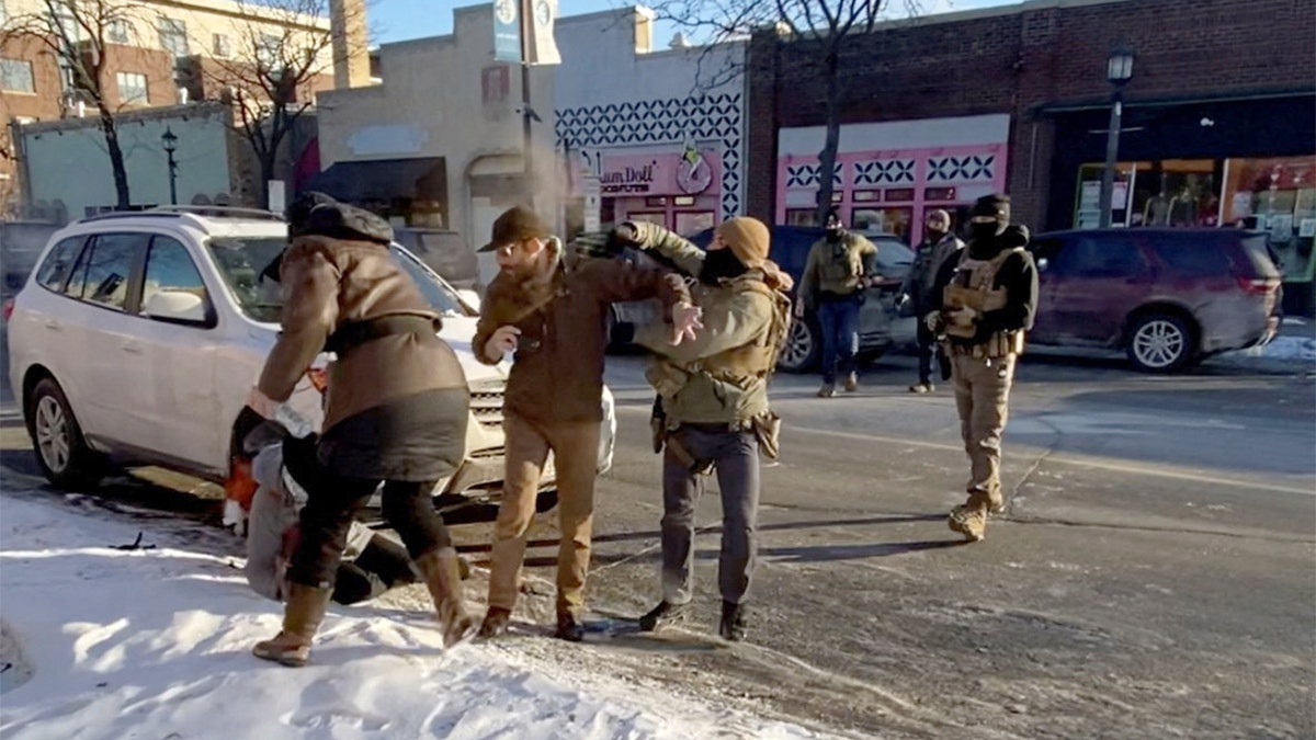 Un agente de la ley utiliza un spray químico contra un hombre durante un enfrentamiento en una calle de la ciudad.