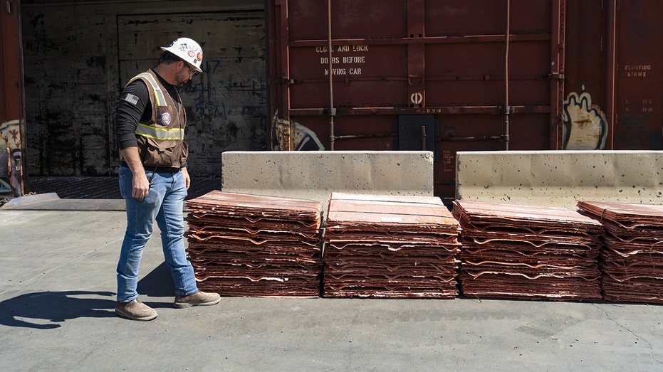 Minero pasa junto a placas de cobre